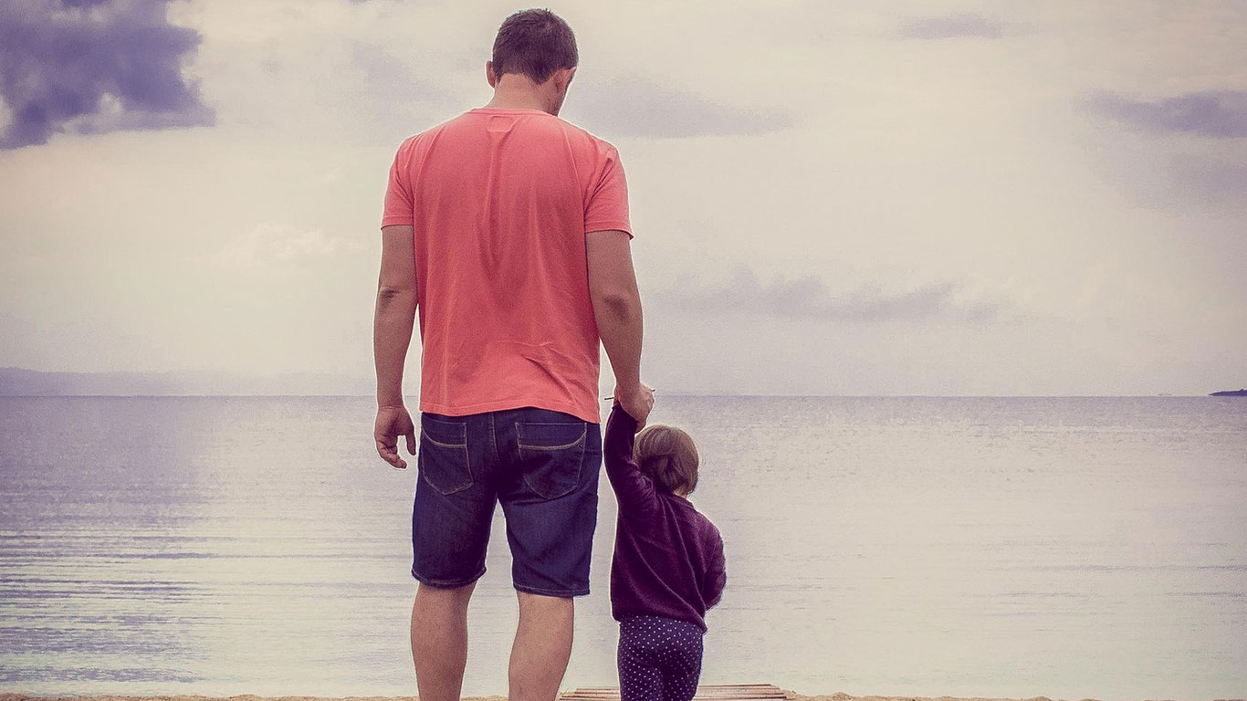 Sparen für Kinder? Auf jeden Fall – aber bitte mit Plan! Vater steht mit seinem kleinen Kind auf einem Steg